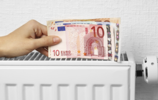 Eine hand hält Geldscheine auf einer Heizung