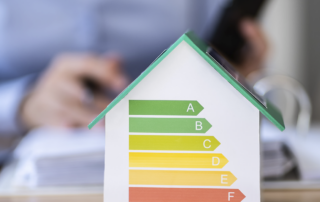 Energiebalken auf einem Miniatur-Modellhaus.