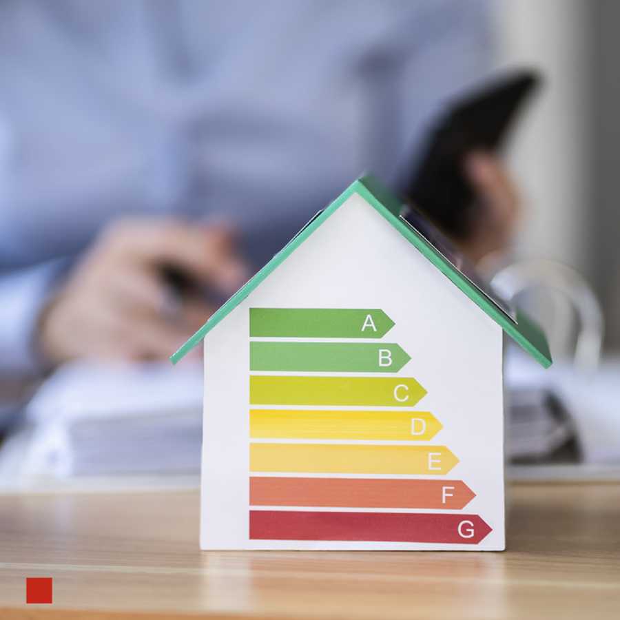 Energiebalken auf einem Miniatur-Modellhaus.