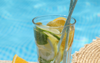 Getränk mit Früchten und Strohhalm am Pool.