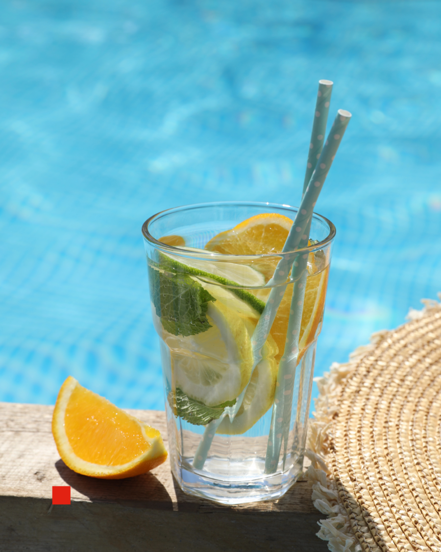 Getränk mit Früchten und Strohhalm am Pool.