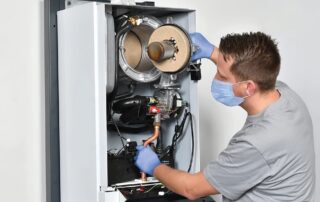 Ein Mechaniker wartet eine Heizungsanlage.